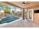 Inviting covered patio featuring a small pool, lush greenery, and a mounted television at 2116 Canvas Edge Dr, Henderson, NV 89044