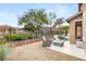 Outdoor patio area with cozy lounge chairs and a built-in fire pit near lush plants at 2116 Canvas Edge Dr, Henderson, NV 89044