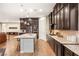 A gourmet kitchen with dark wood cabinets, granite countertops, a large island, and stainless steel appliances at 2116 Canvas Edge Dr, Henderson, NV 89044