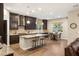 A gourmet kitchen with dark wood cabinets, granite countertops, a large island, and stainless steel appliances at 2116 Canvas Edge Dr, Henderson, NV 89044