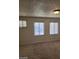 Bedroom with carpet and three windows covered with white blinds at 2417 St George St, North Las Vegas, NV 89030
