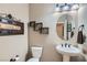Powder bathroom featuring a pedestal sink, decorative mirror, and a unique 