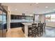 Bright kitchen featuring dark wood cabinets, a granite island with bar seating, and stainless steel appliances at 262 Inflection St, Henderson, NV 89011