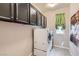 The laundry room has overhead storage cabinets and a window to brighten the space at 262 Inflection St, Henderson, NV 89011