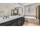 Main bathroom featuring double sinks, a soaking tub, and a separate glass-enclosed shower at 262 Inflection St, Henderson, NV 89011