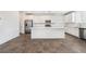 Bright, open kitchen features stainless appliances, white cabinets, large center island, and tile flooring at 2767 Lindsey Springs St, Las Vegas, NV 89142