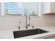 Modern kitchen sink with sleek faucet, sitting beneath a sunny window and blinds at 2767 Lindsey Springs St, Las Vegas, NV 89142