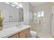 Modern bathroom featuring wood vanity, quartz countertop, oversized mirror, and glass enclosed shower at 2826 Barrow Downs St, Las Vegas, NV 89135