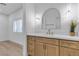 Bathroom vanity with white countertop, light wood cabinets, gold hardware, and plantation shutters at 2826 Barrow Downs St, Las Vegas, NV 89135