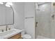 Modern bathroom with sleek vanity, stylish mirror, and glass-enclosed shower with gold fixtures at 2826 Barrow Downs St, Las Vegas, NV 89135