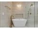 Modern bathroom featuring a freestanding tub with gold accents, a rain shower, and a clear glass shower at 2826 Barrow Downs St, Las Vegas, NV 89135