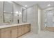 Modern bathroom featuring dual vanities, elegant fixtures, a separate shower, and an adjoining walk-in closet at 2826 Barrow Downs St, Las Vegas, NV 89135