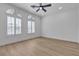 Well lit bedroom featuring wood-look floors, arched windows, and a ceiling fan at 2826 Barrow Downs St, Las Vegas, NV 89135
