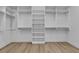 Walk-in closet with custom white shelving and laminate flooring at 2826 Barrow Downs St, Las Vegas, NV 89135