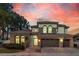 Stunning two-story home featuring a three-car garage and stone accents, set against a vibrant sunset sky at 2826 Barrow Downs St, Las Vegas, NV 89135