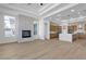 Open-concept living room featuring a stone fireplace, wood-look floors and a modern kitchen at 2826 Barrow Downs St, Las Vegas, NV 89135