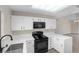 Stylish kitchen with white cabinetry, modern black appliances and elegant countertop at 2851 S Valley View Blvd # 1195, Las Vegas, NV 89102