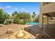 Backyard features a beautiful pool, patio, desert landscaping, and a cozy stone fire pit at 3010 Hammerwood Dr, Las Vegas, NV 89135