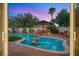 Backyard pool with rock features, cabana, and lush landscaping, visible through the glass door at 3010 Hammerwood Dr, Las Vegas, NV 89135