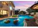 Backyard pool at dusk with stone accents and a tiki hut; a perfect place to relax and unwind at 3010 Hammerwood Dr, Las Vegas, NV 89135