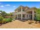 Expansive backyard with covered patio, lush landscaping, outdoor firepit, and access to second story balcony at 3010 Hammerwood Dr, Las Vegas, NV 89135
