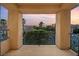 Balcony view features wrought iron railing and serene neighborhood landscape with palm trees at sunset at 3010 Hammerwood Dr, Las Vegas, NV 89135
