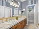 Bright bathroom with double sink vanity, white tile countertops, and patterned wallpaper at 3010 Hammerwood Dr, Las Vegas, NV 89135