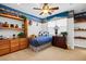 Cozy bedroom with a ceiling fan, built in shelving, a blue plaid bed, and neutral carpet at 3010 Hammerwood Dr, Las Vegas, NV 89135