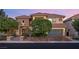Charming two-story house featuring a tile roof, stone accents, and mature landscaping at 3010 Hammerwood Dr, Las Vegas, NV 89135