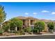 Beautiful two-story home featuring a tile roof, stone accents, and lush landscaping under a clear blue sky at 3010 Hammerwood Dr, Las Vegas, NV 89135