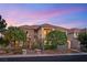 Beautiful two-story home featuring a tile roof, stone accents, and lush landscaping at dusk at 3010 Hammerwood Dr, Las Vegas, NV 89135