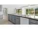 Large open kitchen and island with sink and gray cabinets, with views of the backyard pool and patio at 3010 Hammerwood Dr, Las Vegas, NV 89135