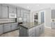 Modern kitchen island with gray cabinets, granite counters, and stainless appliances, plus a door to laundry room at 3010 Hammerwood Dr, Las Vegas, NV 89135
