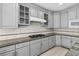 Close-up of modern gray kitchen with granite counters, stainless steel appliances, and white tiled backsplash at 3010 Hammerwood Dr, Las Vegas, NV 89135