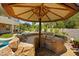 Inviting outdoor kitchen under a tiki-style umbrella, featuring a built-in grill and stone accents at 3010 Hammerwood Dr, Las Vegas, NV 89135
