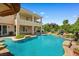 A beautiful backyard pool with tropical landscaping, mature trees, and a waterfall feature at 3010 Hammerwood Dr, Las Vegas, NV 89135