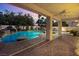 Gorgeous pool area with a rock waterfall feature and covered patio with ceiling fan at 3010 Hammerwood Dr, Las Vegas, NV 89135