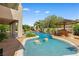 Resort-style pool area featuring rock features, a tiki hut, mature tropical landscaping, and a covered patio at 3010 Hammerwood Dr, Las Vegas, NV 89135