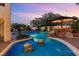 Stunning swimming pool with rock features, in-pool seating, and a built-in outdoor kitchen area at 3010 Hammerwood Dr, Las Vegas, NV 89135
