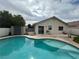 A kidney-shaped pool in a backyard with the house and storage shed at 3729 Bronco Billy Ct, Las Vegas, NV 89129