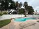 An in-ground kidney-shaped pool is surrounded by trees and grass at 3729 Bronco Billy Ct, Las Vegas, NV 89129