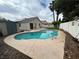 Backyard view of a kidney-shaped pool, concrete patio, palm trees, and storage shed in a fenced yard at 3729 Bronco Billy Ct, Las Vegas, NV 89129