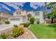 Two story stucco home with tile roof, lush lawn, mature trees and attached two car garage at 4 Tarryall Ter, Henderson, NV 89074