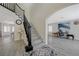 Inviting foyer featuring wood staircase, light gray floors and arched doorway to living area at 4 Tarryall Ter, Henderson, NV 89074