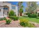 A well-maintained front yard with lush green lawn, mature trees, colorful flowers, and meticulous landscaping at 4 Tarryall Ter, Henderson, NV 89074