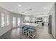 Bright, open kitchen featuring modern white cabinets, large island, stainless appliances and pendant lighting at 4 Tarryall Ter, Henderson, NV 89074