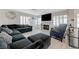Comfortable living room with fireplace, gray floors, large sofa and plantation shutters at 4 Tarryall Ter, Henderson, NV 89074