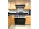 Close-up view of a stainless steel range with maple wood cabinets at 4248 Tara Ave # 2, Las Vegas, NV 89102