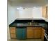 Bright kitchen with black countertops, wood cabinets, stainless steel sink and modern appliances at 4248 Tara Ave # 2, Las Vegas, NV 89102
