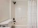 Bathtub in bathroom is tiled with white tile and includes a shower head and curtain rod and is next to a toilet at 427 Wright Way, Henderson, NV 89015
